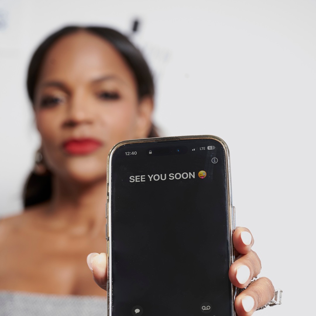 Atoya Burleson holding a phone with a Ladies Playbook message